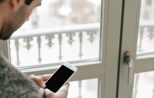 janelas segurança FREEPIK homem-sem-rosto-usando-o-smartphone-perto-da-janela.jpg